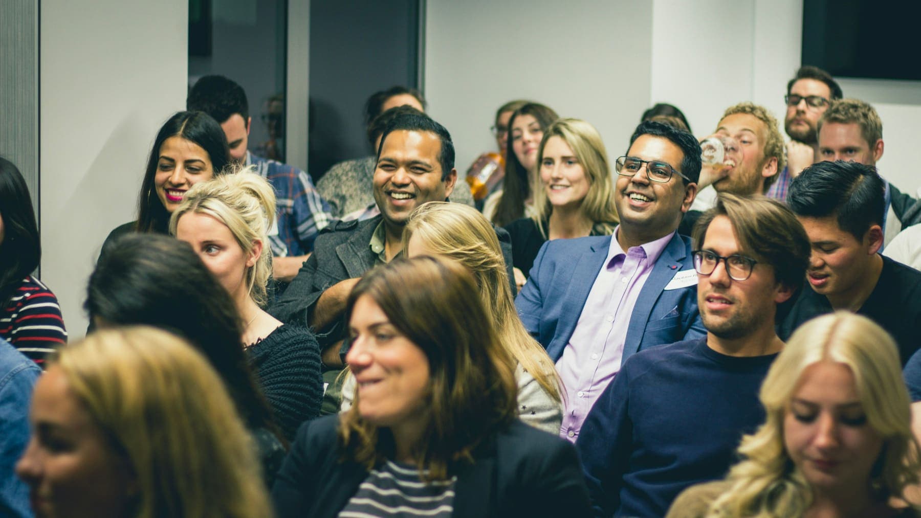 A packed, smiling conference audience