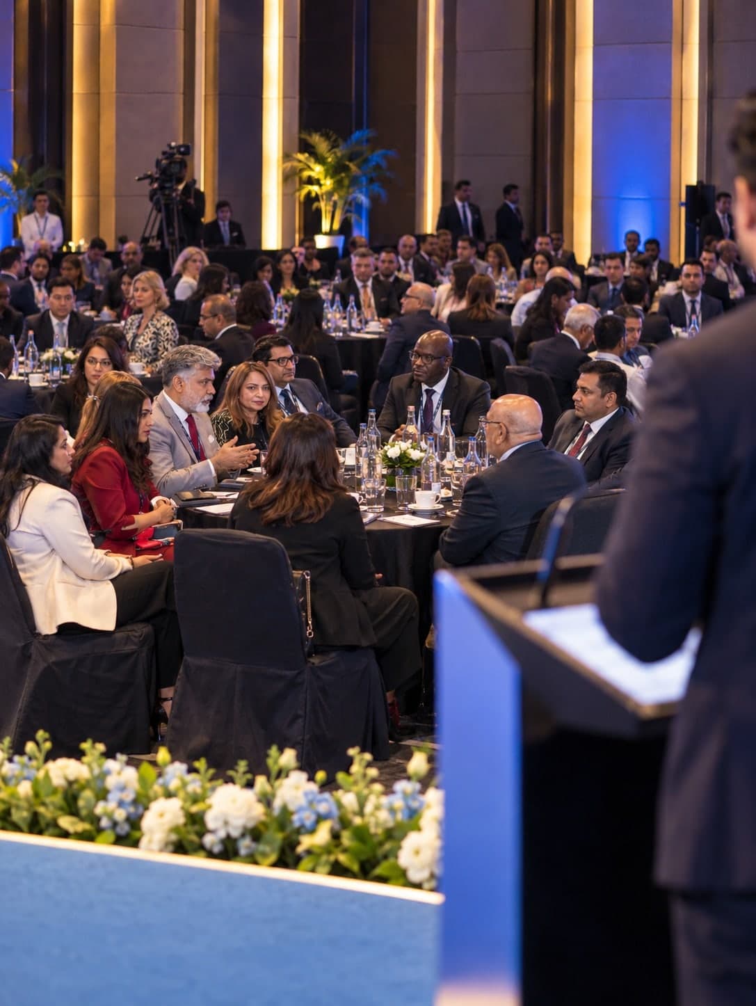 Delegates seated at round tables in a business forum hall