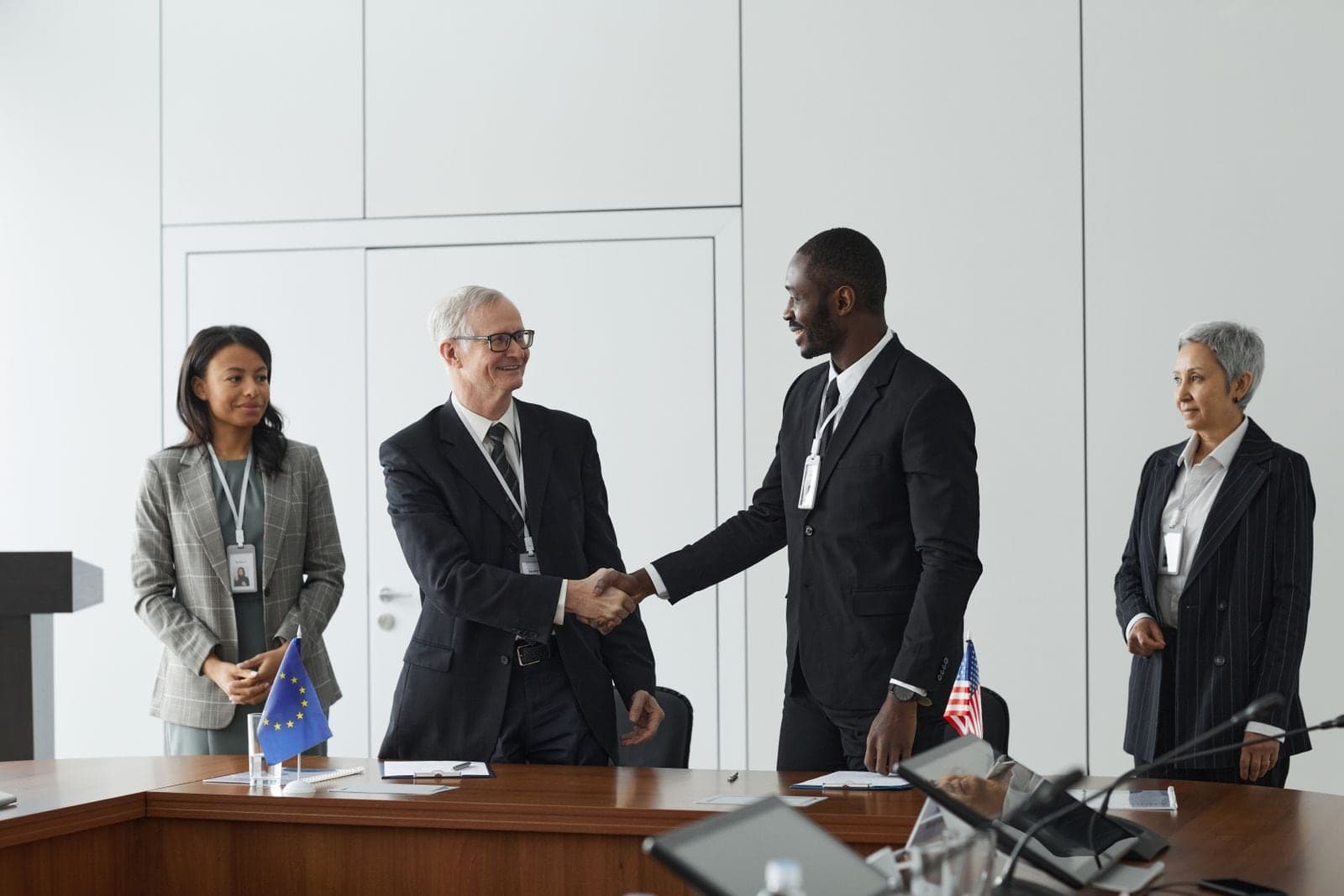 Two business leaders shaking hands at a signing table
