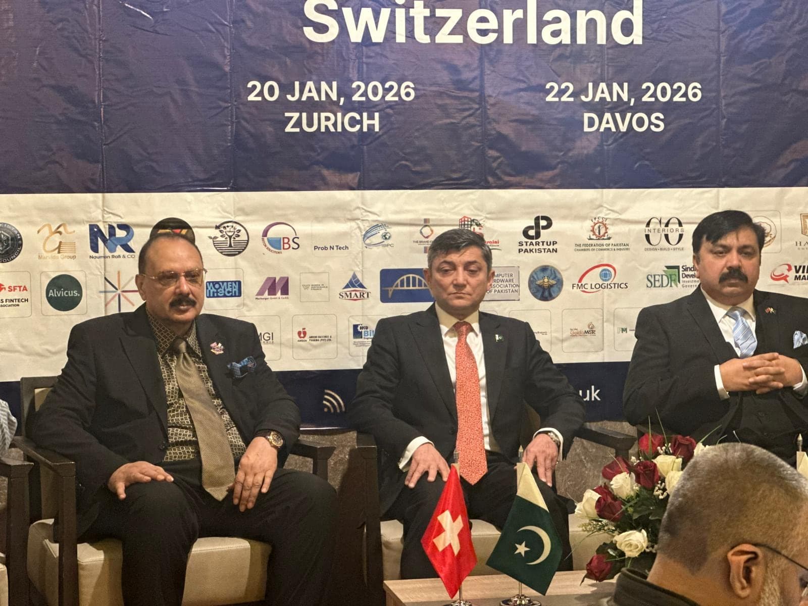 Three business leaders seated together at a business event