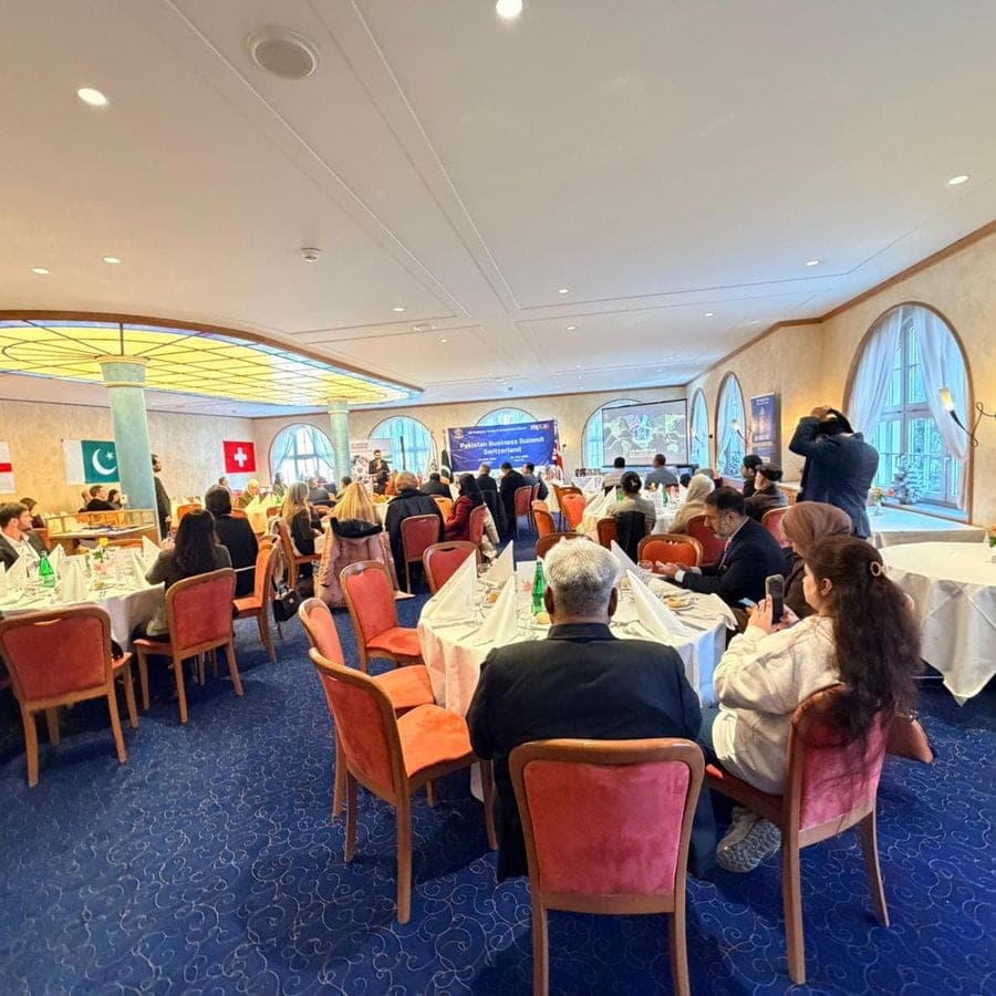 Delegates seated at round tables in a bright event hall