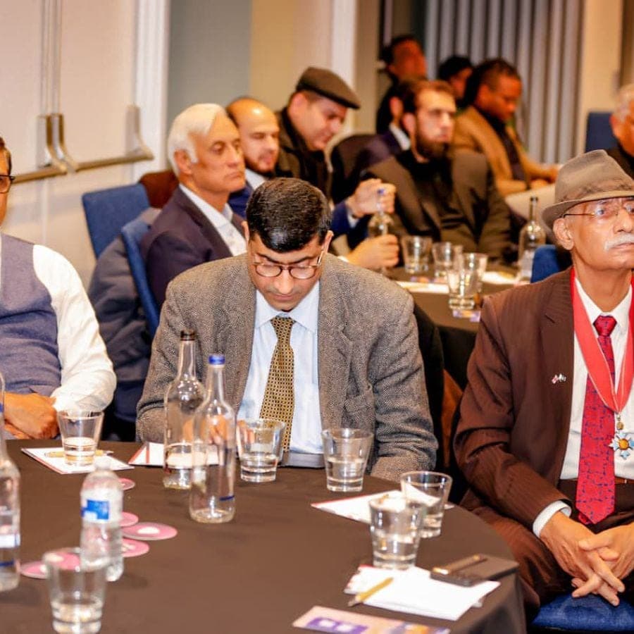 Delegates seated at round tables during a business forum