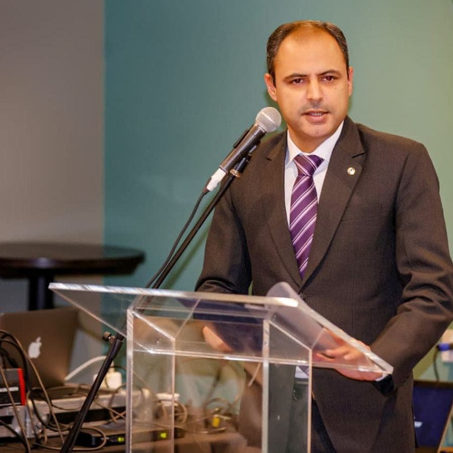 A speaker presenting from a glass lectern