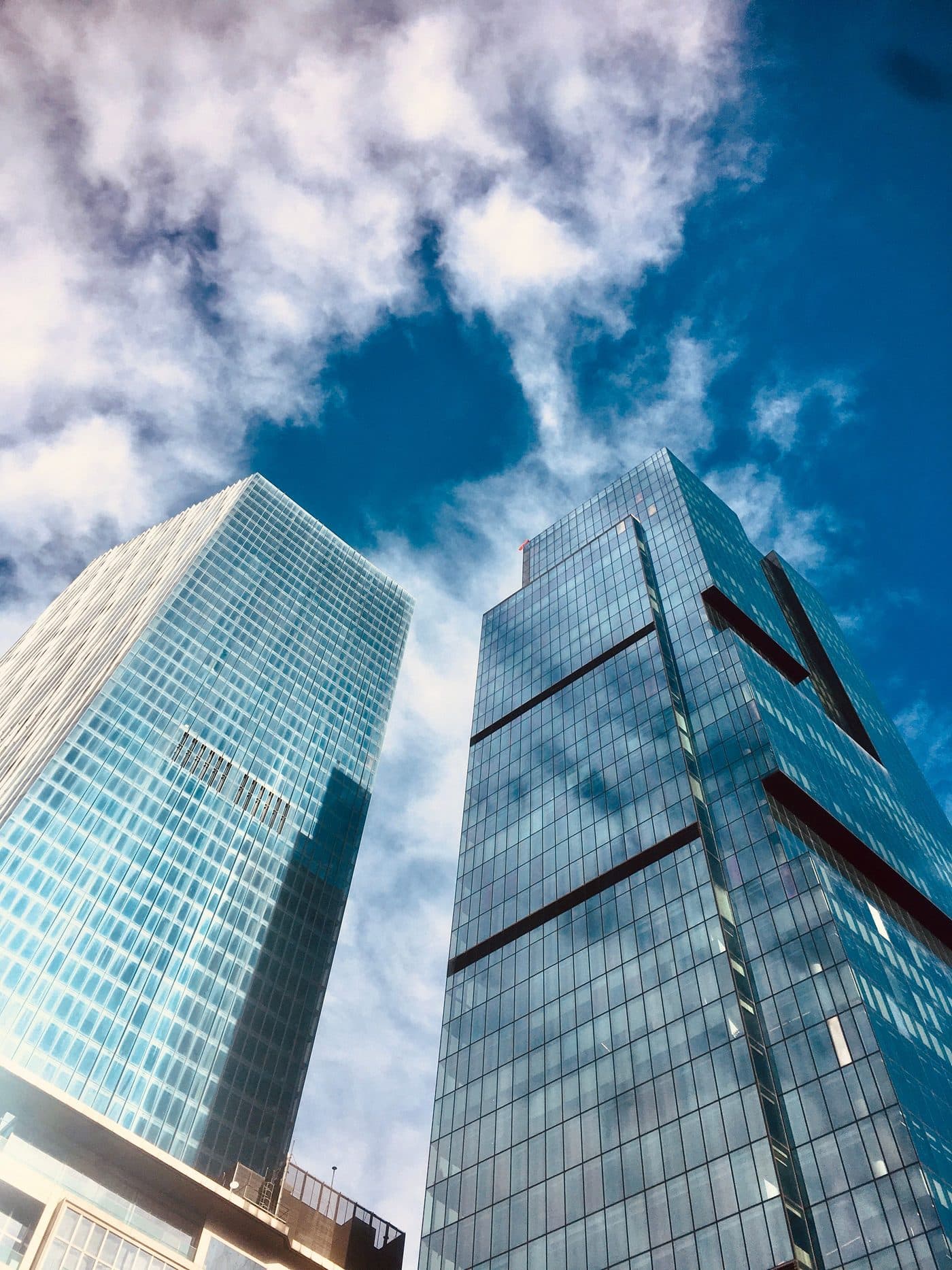 Glass office towers rising against a blue sky