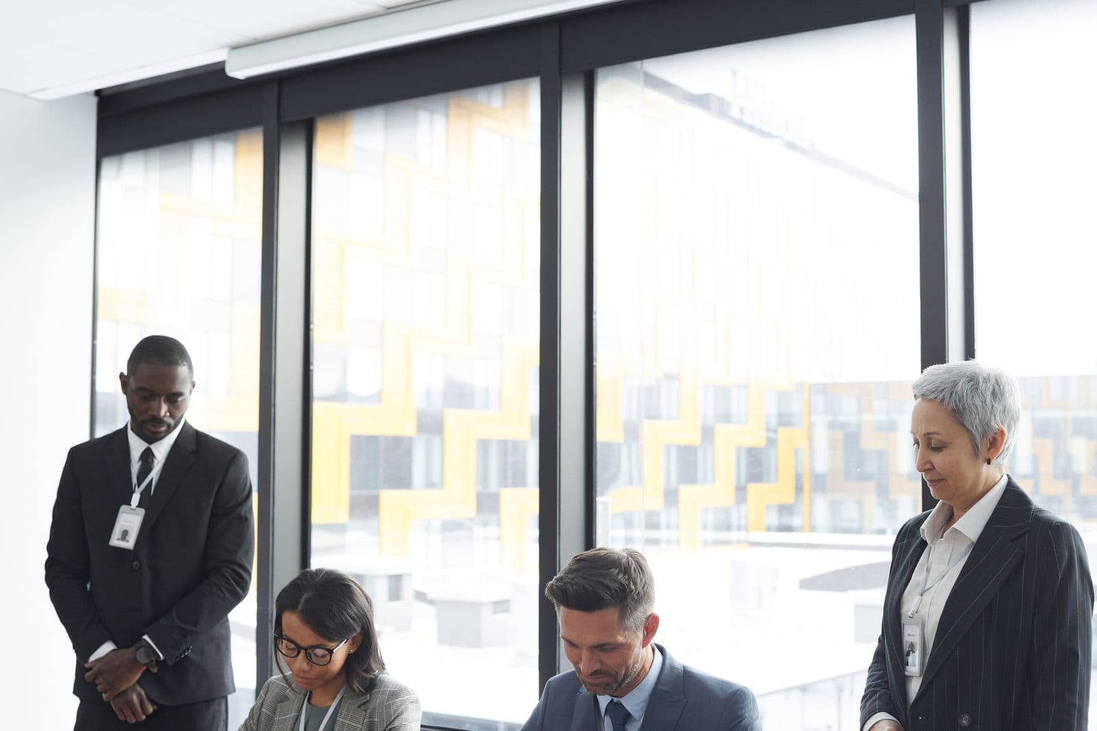 A mixed group of business professionals gathered around a table in a meeting room